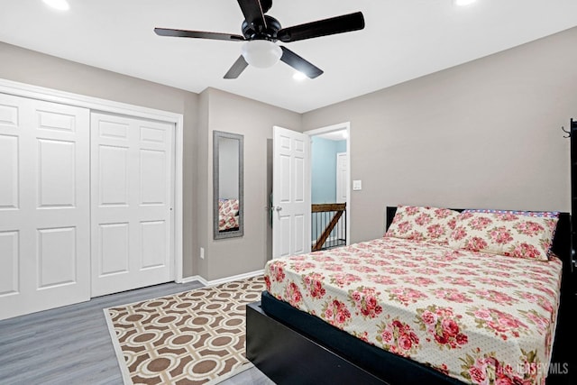 bedroom with a closet, wood finished floors, recessed lighting, ceiling fan, and baseboards