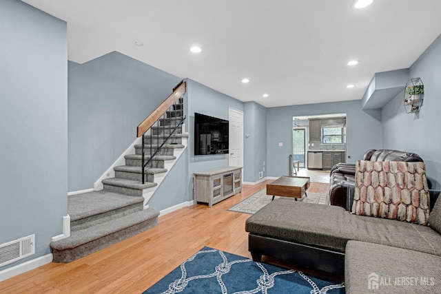 living area with wood finished floors, visible vents, recessed lighting, stairway, and baseboards