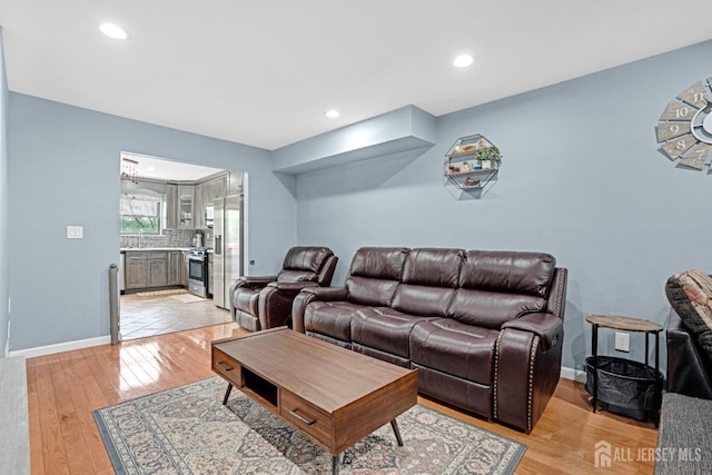 living room featuring light wood-style flooring, baseboards, and recessed lighting