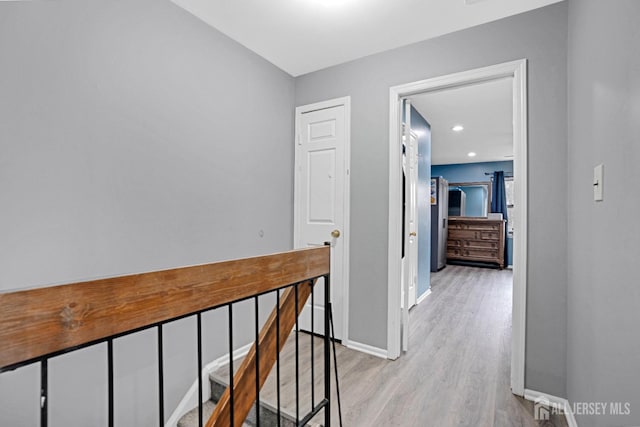 corridor with light wood-type flooring and baseboards