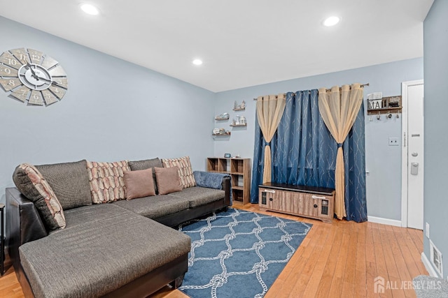 living room with baseboards, hardwood / wood-style floors, and recessed lighting