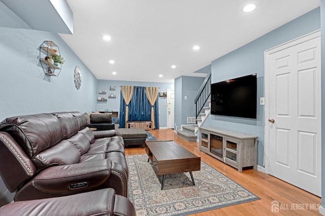 living room featuring light wood-style floors, stairway, and recessed lighting