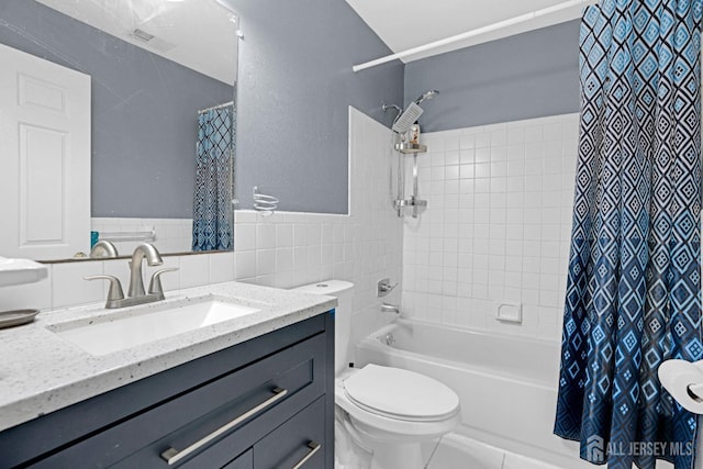 full bathroom with toilet, shower / tub combo with curtain, tile walls, visible vents, and vanity