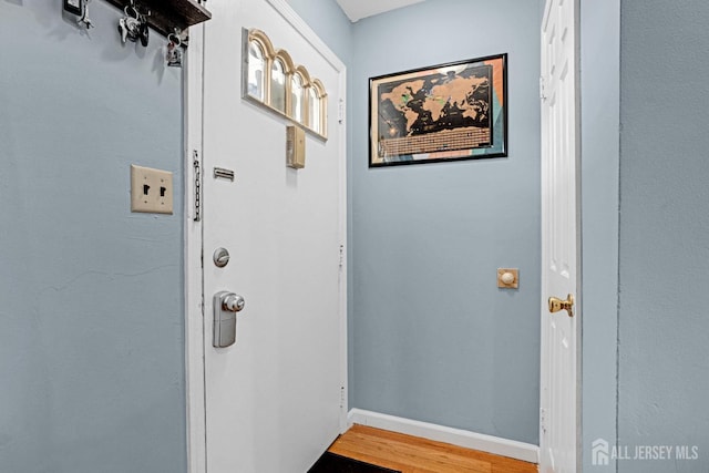 doorway to outside with baseboards and wood finished floors
