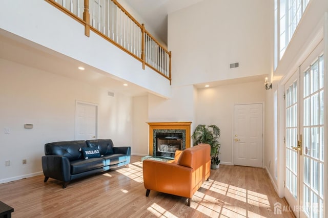 living area featuring visible vents, baseboards, and wood finished floors