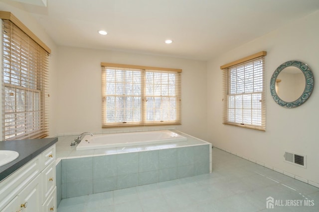 full bathroom featuring tile patterned floors, visible vents, vanity, and a garden tub