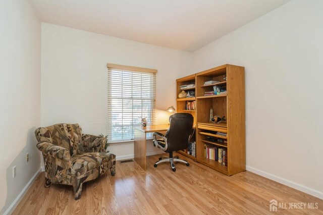 office area with visible vents, baseboards, and wood finished floors