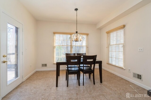 dining room with visible vents, plenty of natural light, and an inviting chandelier