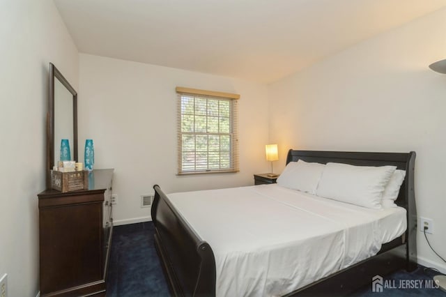 bedroom featuring baseboards, visible vents, and dark carpet