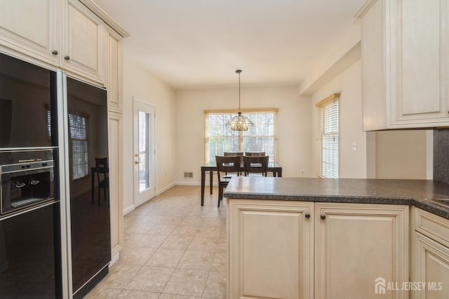 kitchen featuring black fridge with ice dispenser, dark countertops, cream cabinets, an inviting chandelier, and a peninsula