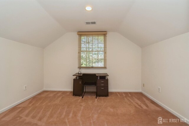 unfurnished office featuring visible vents, lofted ceiling, light colored carpet, and baseboards