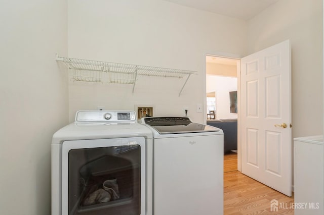 laundry room featuring washer and clothes dryer, laundry area, and light wood-style flooring