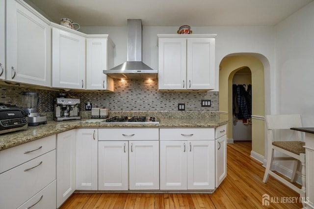 1156 Kline Pl, Rahway, NJ 07065 - kitchen featuring wall chimney exhaust hood, tasteful backsplash, white cabinetry, and light wood-type flooring