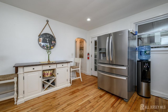 1156 Kline Pl, Rahway, NJ 07065 - kitchen with stainless steel fridge with ice dispenser, arched walkways, white cabinetry, light wood finished floors, and dark countertops