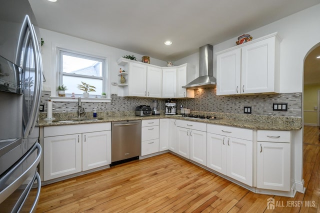 1156 Kline Pl, Rahway, NJ 07065 - kitchen with stainless steel appliances, light wood-style floors, arched walkways, white cabinetry, and tasteful backsplash