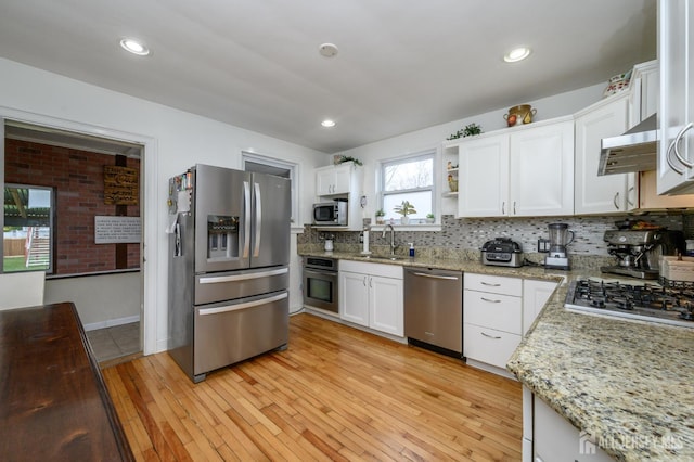 1156 Kline Pl, Rahway, NJ 07065 - kitchen featuring appliances with stainless steel finishes, extractor fan, white cabinetry, tasteful backsplash, and light wood-style floors