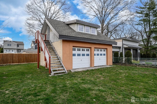 1156 Kline Pl, Rahway, NJ 07065 - view of side of home with stairs, a garage, a shingled roof, a fenced backyard, and stucco siding