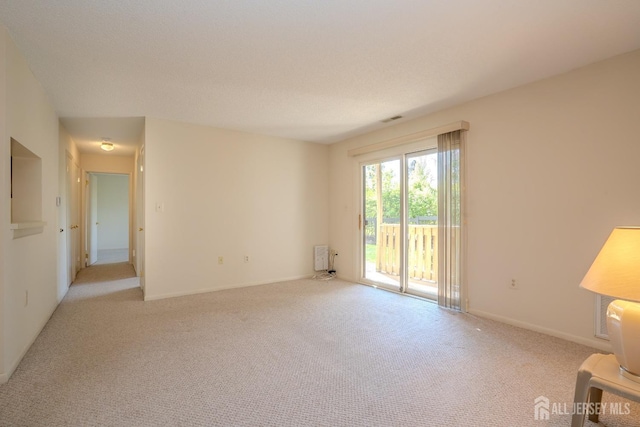 spare room featuring carpet floors and baseboards