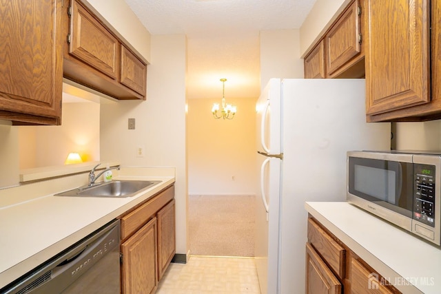 kitchen featuring a sink, dishwasher, stainless steel microwave, light countertops, and a chandelier