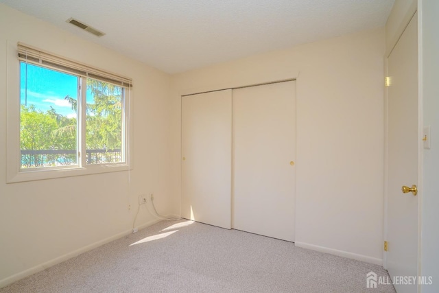 unfurnished bedroom with carpet flooring, baseboards, and a closet