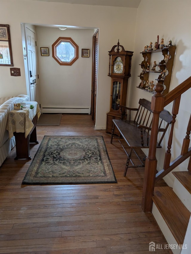 entrance foyer featuring stairs, baseboard heating, and wood-type flooring