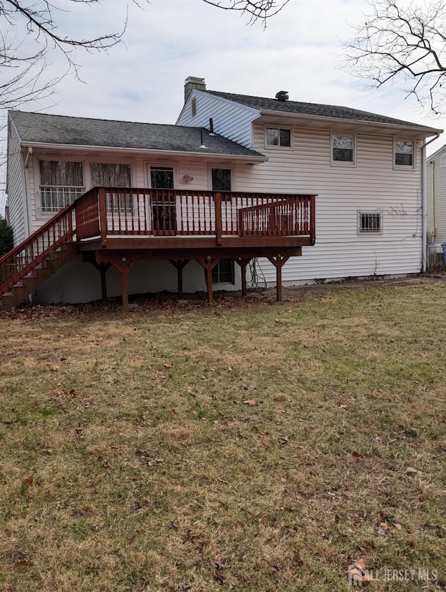 back of house with a deck, a lawn, and a chimney