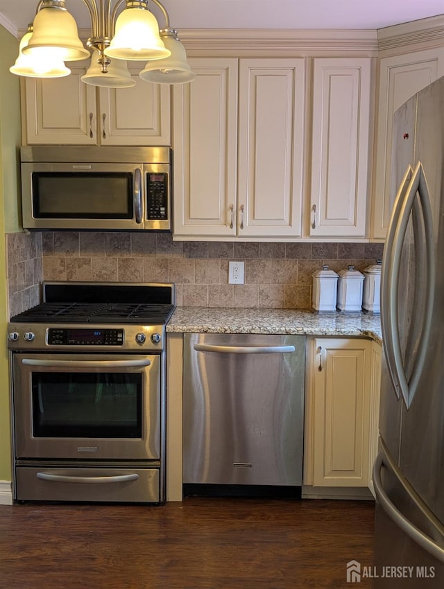 kitchen featuring light stone counters, dark wood-style floors, tasteful backsplash, and appliances with stainless steel finishes