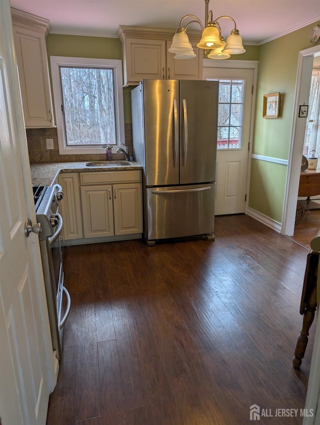 kitchen featuring dark wood-type flooring, ornamental molding, a sink, tasteful backsplash, and appliances with stainless steel finishes