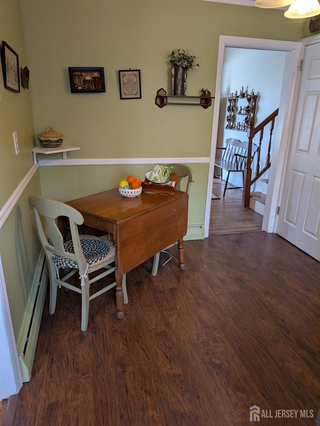 dining area with stairs, wood finished floors, and a baseboard radiator