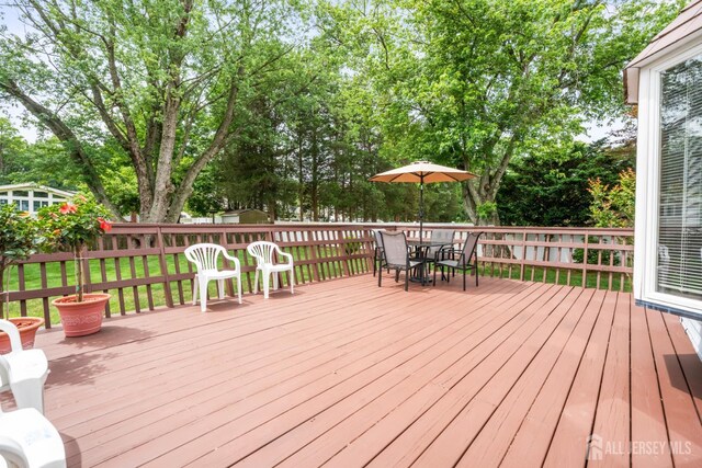 44 Frost Ave, East Brunswick, NJ 08816 - wooden terrace with outdoor dining area and view of wooded area