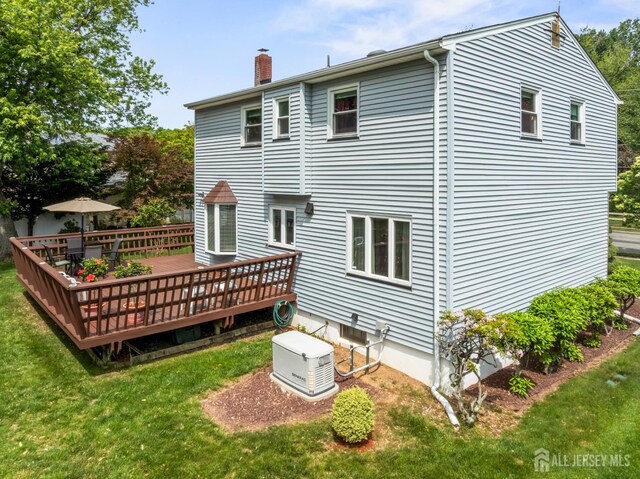 44 Frost Ave, East Brunswick, NJ 08816 - rear view of house with a chimney, a deck, and a lawn