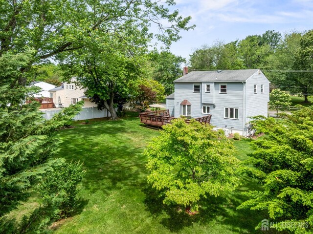44 Frost Ave, East Brunswick, NJ 08816 - back of house with a chimney, a deck, and view of wooded area