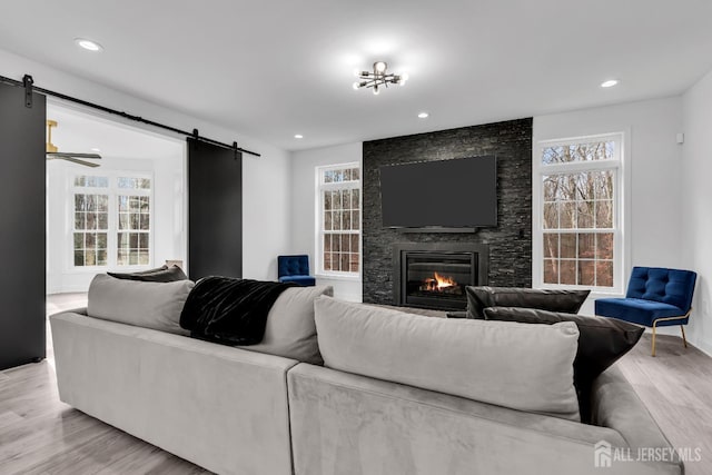 131-B Dutch Rd, East Brunswick, NJ 08816 - living room with a barn door, light wood-style flooring, a fireplace, plenty of natural light, and recessed lighting