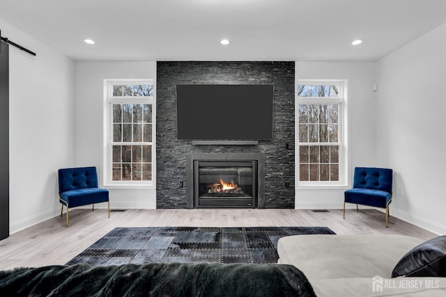 131-B Dutch Rd, East Brunswick, NJ 08816 - living area with wood finished floors, a stone fireplace, baseboards, a barn door, and recessed lighting