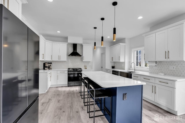 131-B Dutch Rd, East Brunswick, NJ 08816 - kitchen with black appliances, wall chimney range hood, a sink, a breakfast bar, and tasteful backsplash