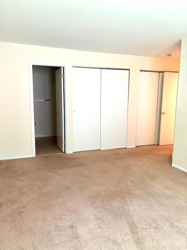 2102 Bayhead Dr Unit 2102, Sayreville, NJ 08859 - unfurnished bedroom with multiple closets, light carpet, and ensuite bathroom