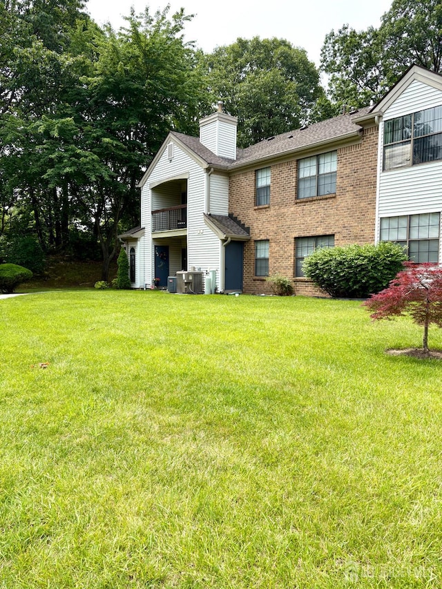 2102 Bayhead Dr Unit 2102, Sayreville, NJ 08859 - view of front of property with a chimney, brick siding, a front lawn, and a balcony