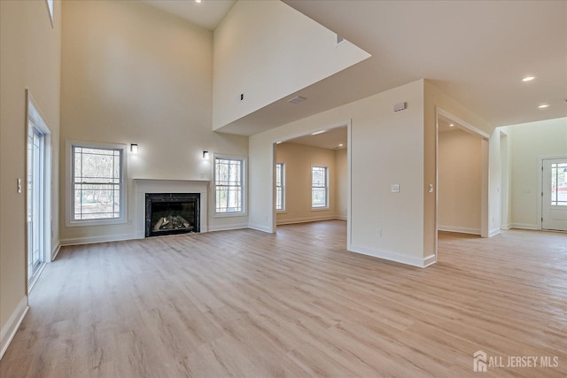 90 Hancock Rd, Piscataway, NJ 08854 - unfurnished living room featuring light wood-style flooring, a glass covered fireplace, and recessed lighting