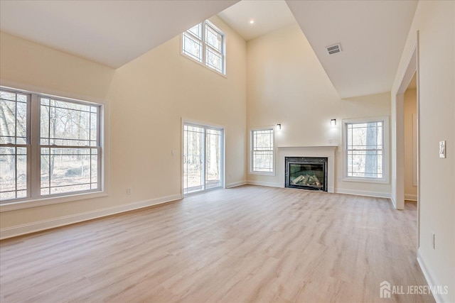90 Hancock Rd, Piscataway, NJ 08854 - unfurnished living room featuring light wood-style flooring, a glass covered fireplace, and a high ceiling