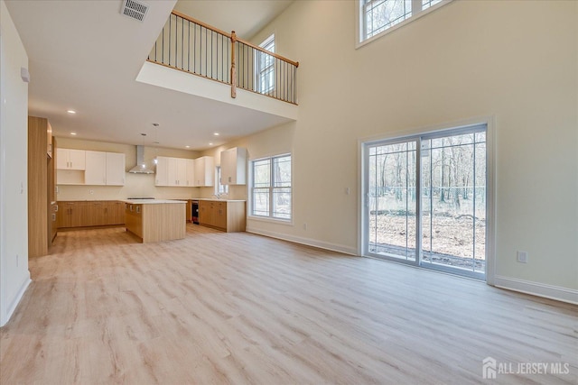 90 Hancock Rd, Piscataway, NJ 08854 - unfurnished living room featuring healthy amount of natural light, light wood-style floors, a high ceiling, and recessed lighting