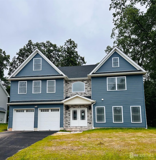 90 Hancock Rd, Piscataway, NJ 08854 - view of front of house with stone siding, an attached garage, driveway, and a front lawn