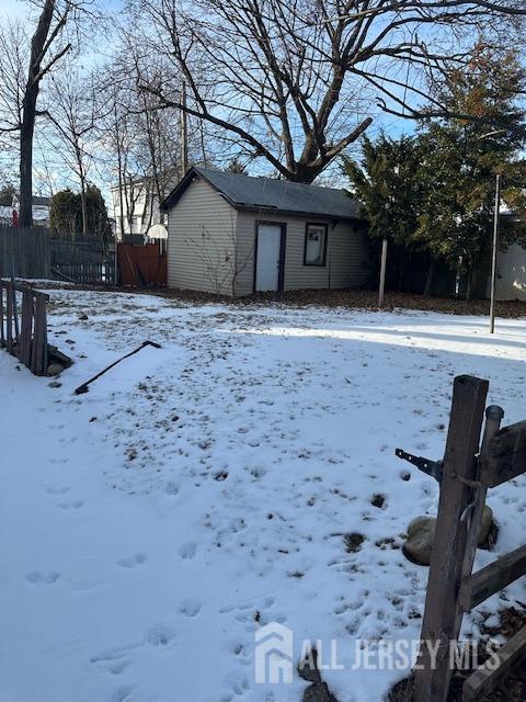 yard covered in snow with an outbuilding