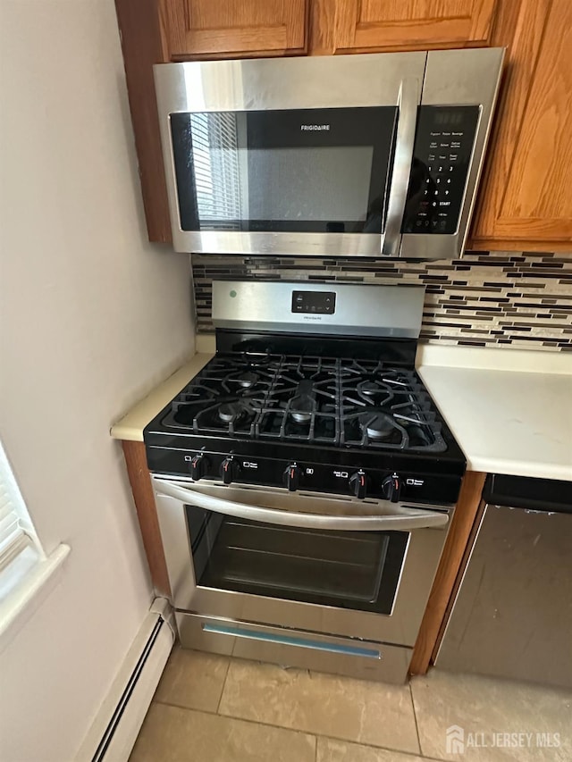 66 Fox Rd Unit 10A, Edison, NJ 08817 - kitchen view of stainless steel appliances, tasteful backsplash, brown cabinetry, light countertops, and baseboard heating