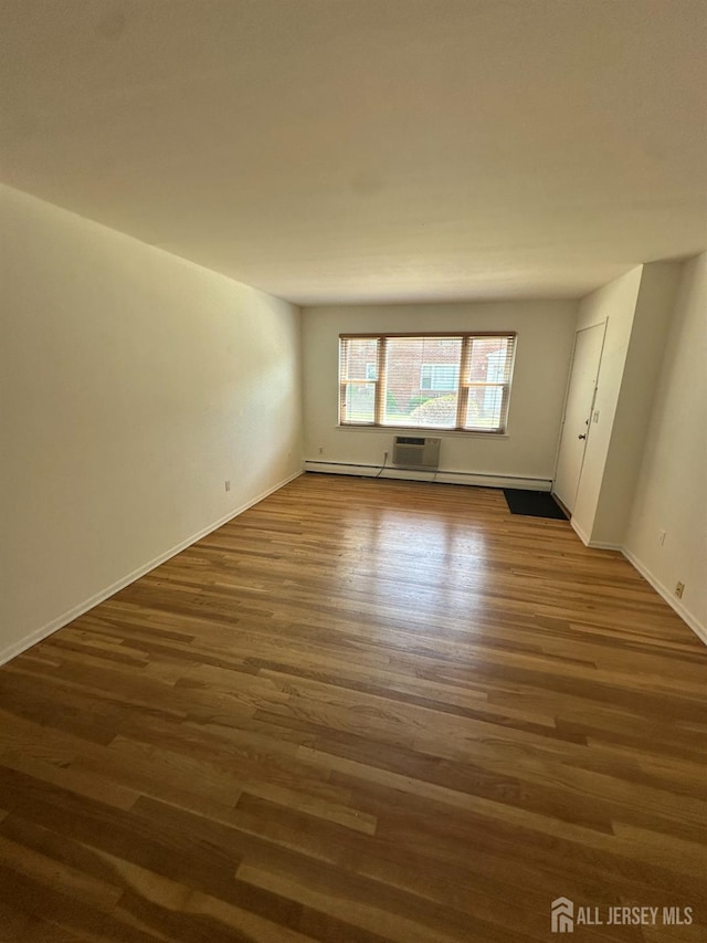 66 Fox Rd Unit 10A, Edison, NJ 08817 - spare room featuring dark wood-type flooring, an AC wall unit, and baseboard heating