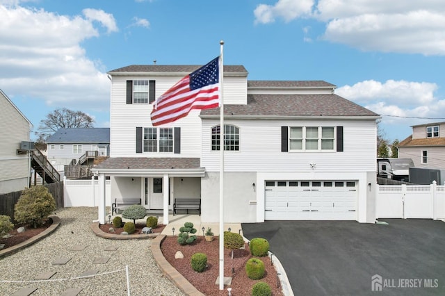 415 Lorillard Ave, Union Beach, NJ 07735 - traditional-style house featuring covered porch, fence, an attached garage, and aphalt driveway