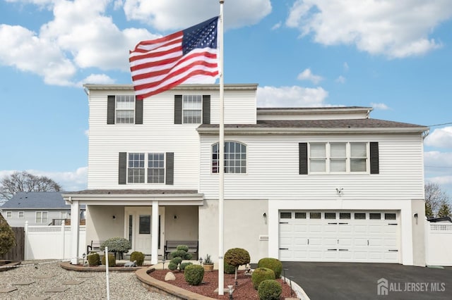 415 Lorillard Ave, Union Beach, NJ 07735 - view of front facade featuring fence, roof with shingles, a garage, a porch, and driveway