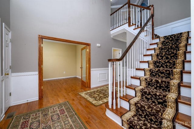 foyer featuring a towering ceiling and light hardwood / wood-style flooring