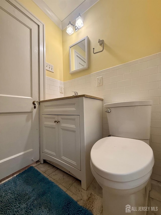 451 E Main St, Somerville, NJ 08876 - bathroom featuring tile walls, marble look tiles, vanity, a wainscoted wall, and toilet