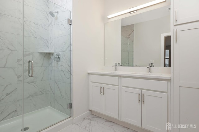 full bathroom featuring a stall shower, marble finish floor, and a sink