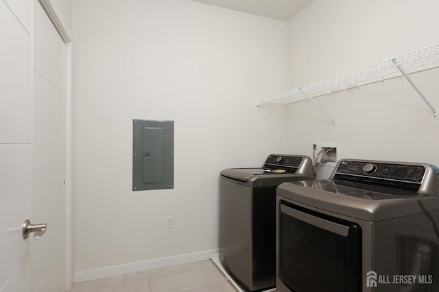 clothes washing area with light tile patterned floors, baseboards, laundry area, electric panel, and independent washer and dryer